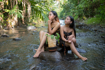 Wall Mural - Portrait of beautiful two young Asian girls in river