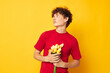 © Tatiana - Young curly-haired man in a red t-shirt a bouquet of flowers holiday gift Lifestyle unaltered
