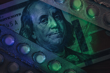 Poster - Pills or drugs and dollars cash money in a package under neon light on a dark background pattern for design..