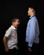 © Сергей Везнер - Two boys on a black background are brothers.Senior and junior.Atelier.The younger one is laughing at the older brother