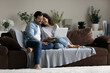 © fizkes - Peaceful couple in love relaxing on cozy sofa with laptop. Carefree beautiful spouses watch funny videos, comedy movie on internet spend weekend together at home. Modern tech, family leisure concept