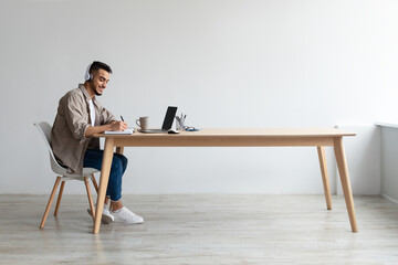 Aufkleber - Portrait of smiling Arab man using laptop and writing