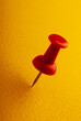 © APHOTOSTUDIO - Red vinyl paper clip on yellow paper, close-up.