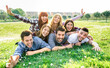 Young people having fun together with self portrait on grass meadow - Youth life style concept with happy friends at picnic camping out side - Warm vivid filter with backlight contrast sunshine