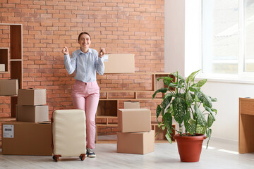 Wall Mural - Happy young woman with key and suitcase in her new flat