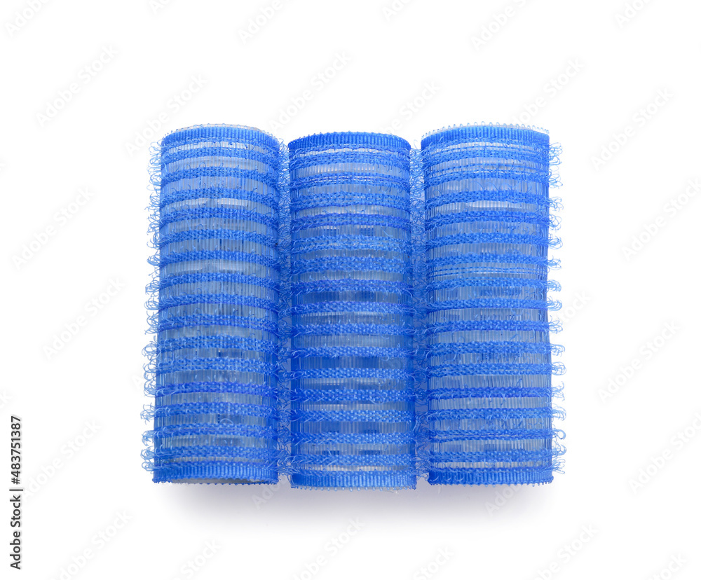 Blue hair curlers on light background
