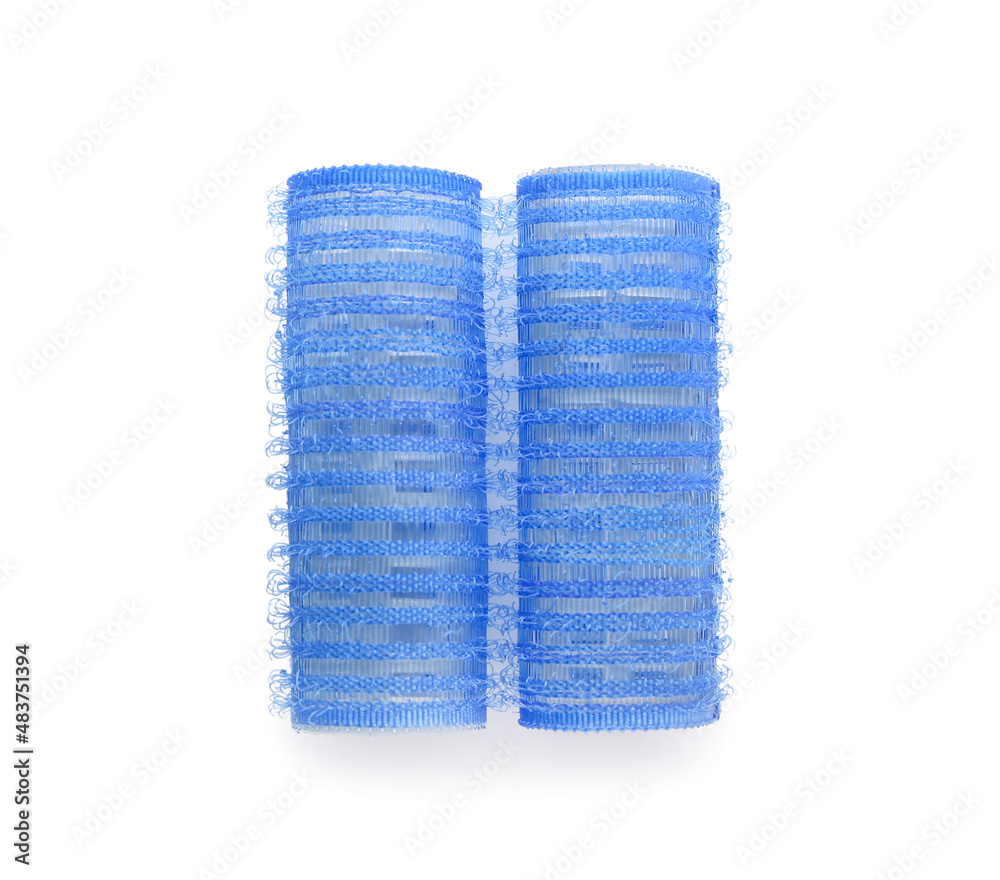 Blue hair curlers on light background