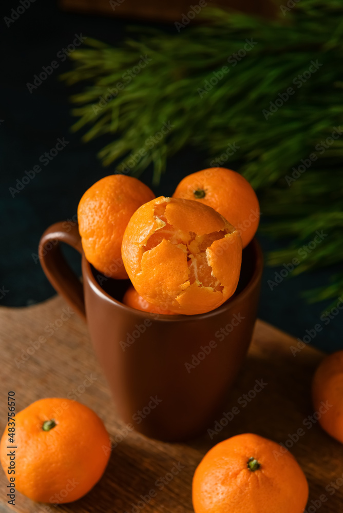 Cup with tangerines on wooden board
