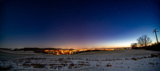 Wall Mural - Panorama of the starry night sky with the light of the city on the horizon