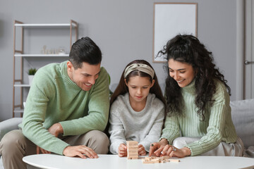 Sticker - Happy family in warm sweaters playing jenga game at home