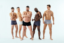 Group Of Multiethnic Men Posing For A Male Edition Body Positive Beauty Set. Shirtless Guys With Different Age, And Body Wearing Boxers Underwear
