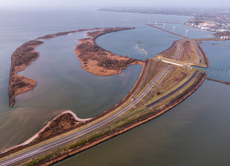 Aerial view on aquaduct infrastructure building during sunrise, water way crossing highway road in the Netherlands