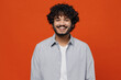 © ViDi Studio - Smiling fascinating cheerful blithesome young bearded Indian man 20s years old wears blue shirt looking camera isolated on plain orange background studio portrait. People emotions lifestyle concept.