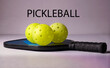 Pickleball paddle and three yellow balls. Pickleball is the fastest growing sport in the US.