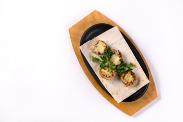 Wall Mural - Baked stuffed mushrooms with mushrooms, cheese and herbs, on a wooden board on a white isolated background