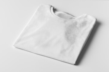 basic folded white tshirt on grey table with copy space. mock up for branding t-shirt. monochrome tr