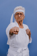 Wall Mural - Funny grandmother portraits.granny fashion model on colored backgrounds. Karate master practicing martial arts