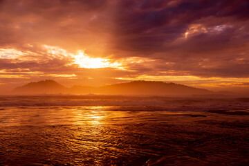 Wall Mural - Warm sunrise with clouds and silhouette of Campeche island in Florianopolis, Brazil