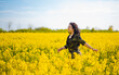 Beautiful woman with long black hair. Portrait made of a chain of yellow flowers. Sunny summer day.