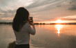 Sexy woman photographed from behind at sunset. She photographs the Danube at sunset.