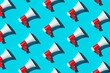© Shawn Hempel - Diagonal array pattern of white and red megaphones or bullhorns over cyan blue background, business announcement or communication concept, flat lay top view from above