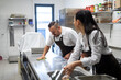 © Halfpoint - Chef and cook cleaning the workspace after doing dishes indoors in restaurant kitchen.