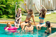 © yurakrasil - group of six friends having fun in swimmingpool outdoors