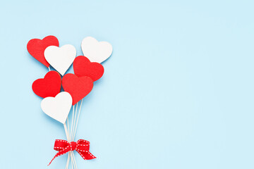 Wall Mural - Valentines Day background. Red and white wooden hearts on a light blue backdrop. Flat lay, copy space