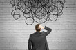 © Who is Danny - Back view of businessman looking at abstract scribble on brick wall background. Question, think and confusion concept.