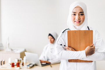 Wall Mural - Professional medical two muslim asian woman doctor team with stethoscope in uniform working and look at camara in hospital.healthcare and medicine