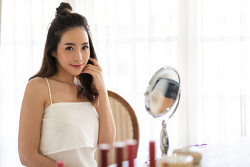 Wall Mural - Smiling of young beautiful pretty asian woman clean fresh healthy white skin looking at camara.asian girl touching on face with hand and applying cream at home.spa and beauty concept