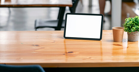 Fototapete - Close-up view of comfortable workplace with mock up digital tablet and tree pot on wooden table.