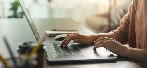 Hands typing keyboard on laptop with working online.