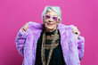 © oneinchpunch - Beautiful and elegant old influencer woman. Cool grandmother posing in studio wearing fashionable clothes. Happy senior lady celebrating and making party. Concept about seniority and lifestyle
