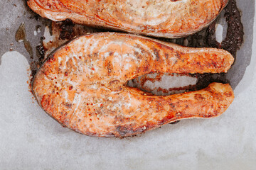 Cooked salmon steaks on a baking sheet close-up. Steaks of red fried fish. Pieces of baked salmon