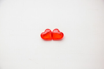 Two small red hearts on a white background, close-up. The concept of holidays and Valentine's Day