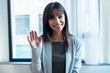 © nenetus - Smiling business woman looking at camera while waving hand at office.