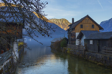 Old traditional Austrian houses on a mountain lake shore on winter sunset