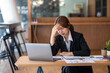 © amnaj - Young Asian businesswoman sitting in the office feeling stressed or tired from work.