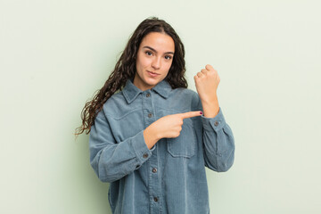 Wall Mural - hispanic pretty woman looking impatient and angry, pointing at watch, asking for punctuality, wants to be on time