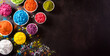 Happy holi festival decoration.Top view of colorful holi powder on dark background with copy space for text.