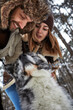 © Georgii - Portrait of a young beautiful couple of European appearance with a husky dog in the winter forest