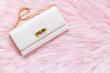 Luxury pink clutch bag on a fur pink background.