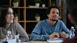 © LIGHTFIELD STUDIOS - young interracial business colleagues smiling during meeting on blurred foreground