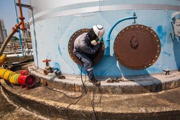 Wall Mural - Male worker into the tank carbon chemical oil interface area confined
