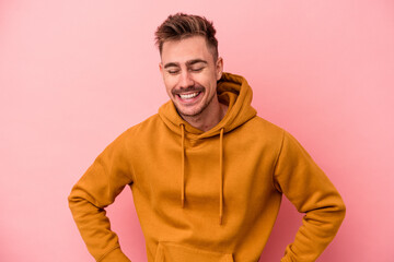 Wall Mural - Young caucasian man isolated on pink background happy, smiling and cheerful.