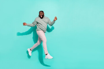 Wall Mural - Full length body size view of attractive cheerful guy jumping going enjoying isolated over bright teal turquoise color background