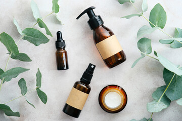 Wall Mural - natural skin care products set with eucalyptus branches on stone table, top view. amber glass cosmet