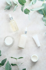 Wall Mural - set of natural cosmetics in transparent containers on marble background with eucalyptus branches. sk