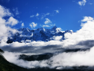 Poster - A scenic view of rocky mountains in Tibet enveloped in clouds